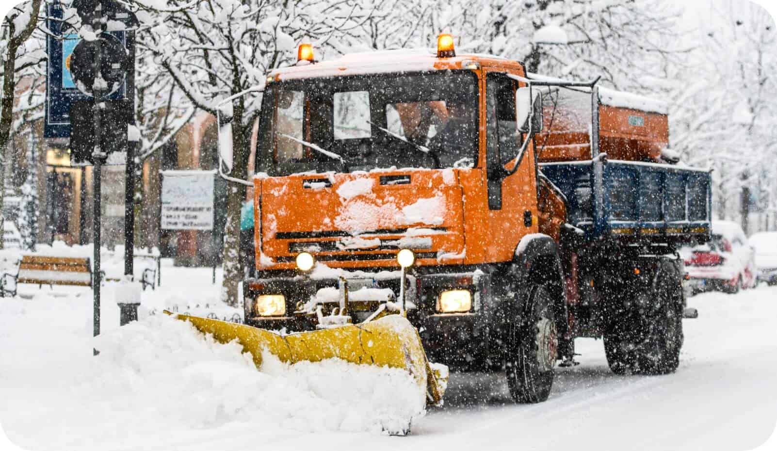 除雪车清理城市街道积雪，展示通过物联网技术优化的市政车队运营